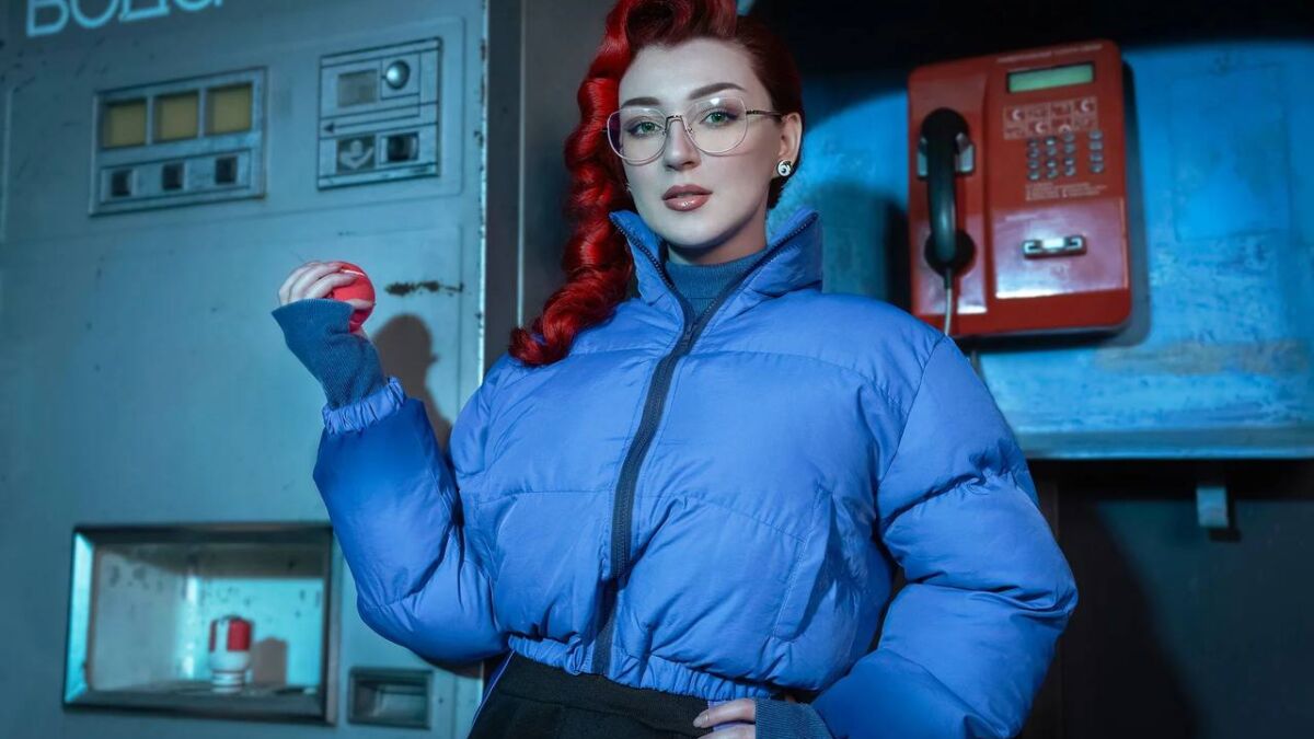 Модель с красными кудрями в синей куртке косплей Анастасии Назаровой Atomic Heart