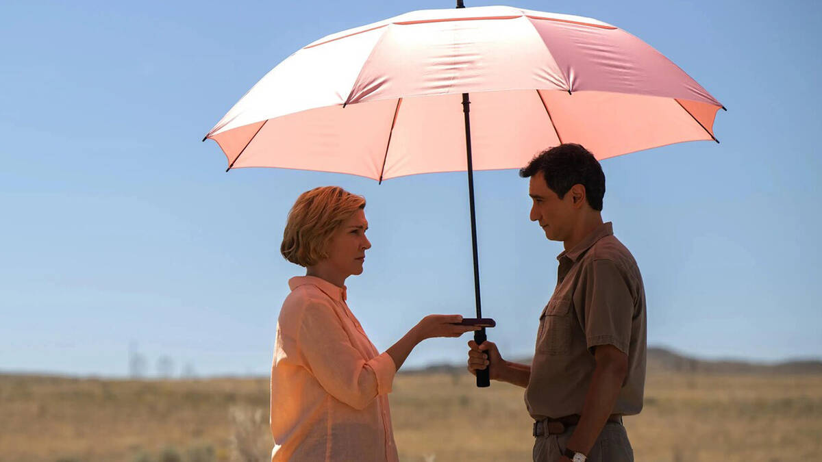 Мужчина и женщина под зонтом на пустом поле