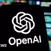 Логотип OpenAI на смартфоне с фоном кода