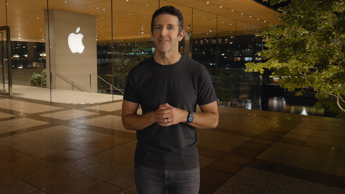 Мужчина в чёрной футболке у магазина Apple на улице