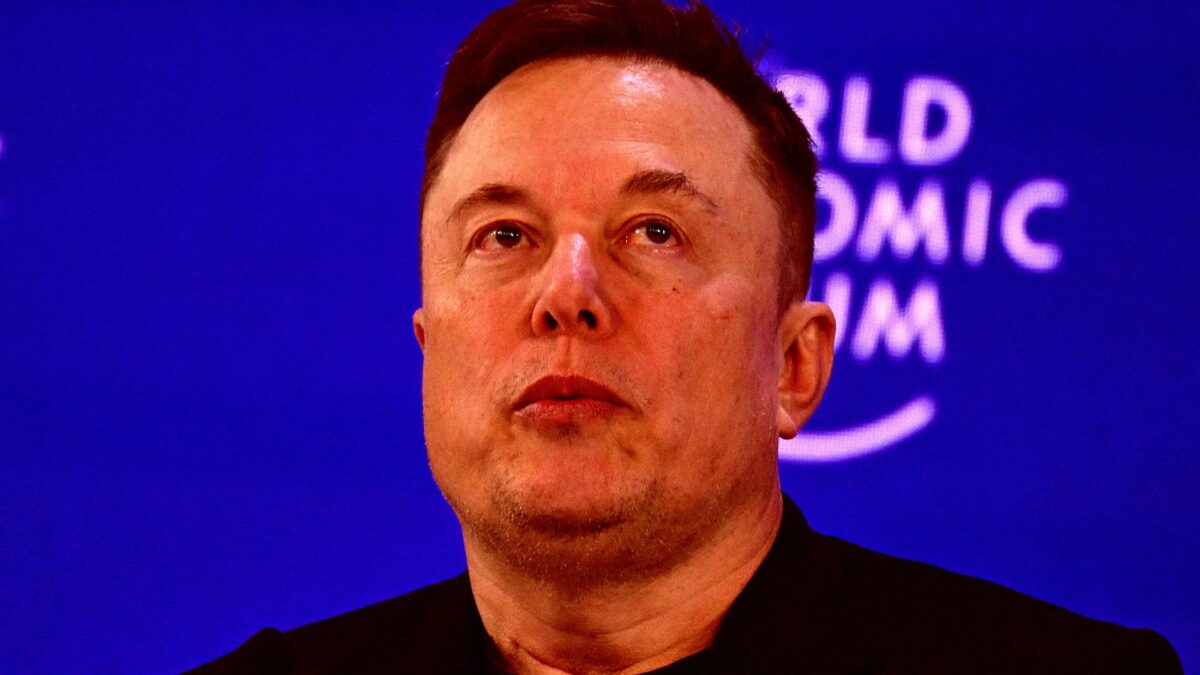 человек в чёрной одежде на сцене с синим экраном