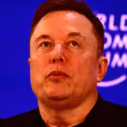 человек в чёрной одежде на сцене с синим экраном