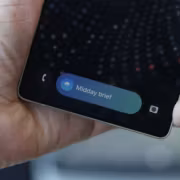 Человек держит телефон Samsung Galaxy с уведомлением Midday brief