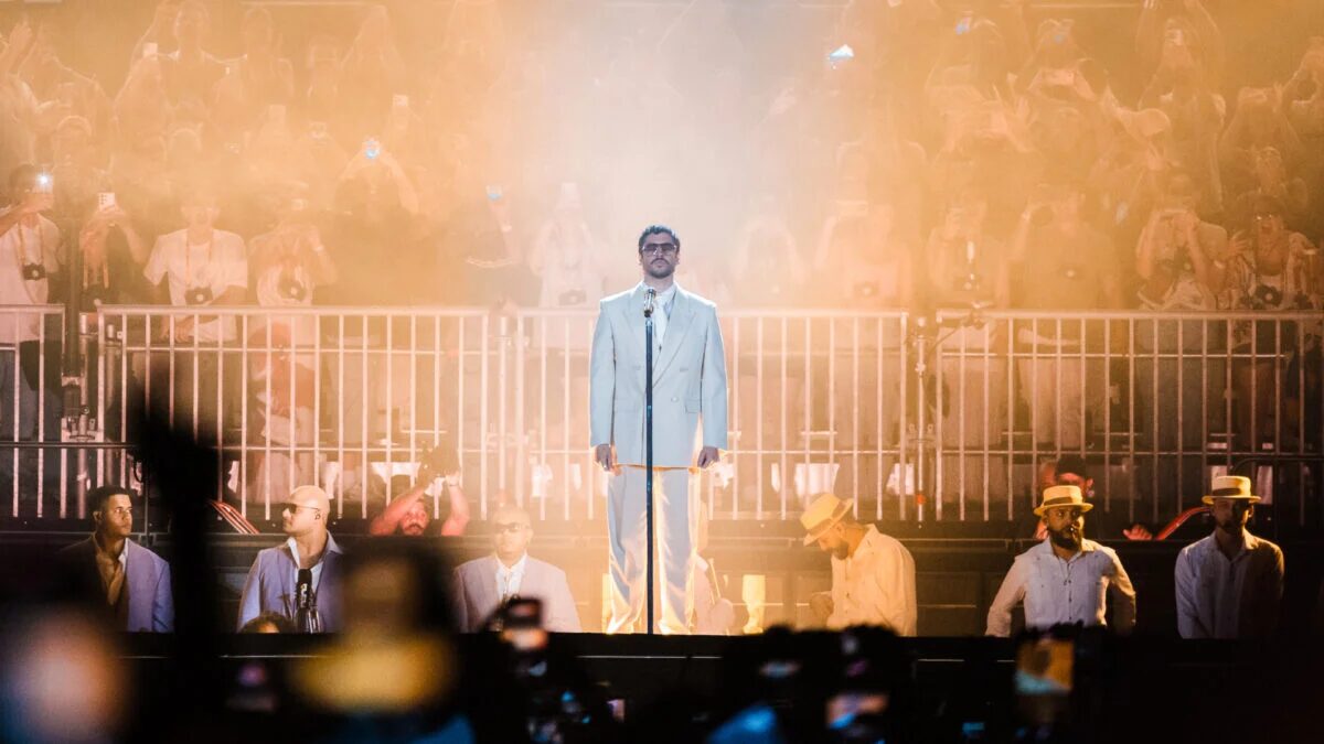 Исполнитель в белом костюме на сцене Spotify показывает топ треков