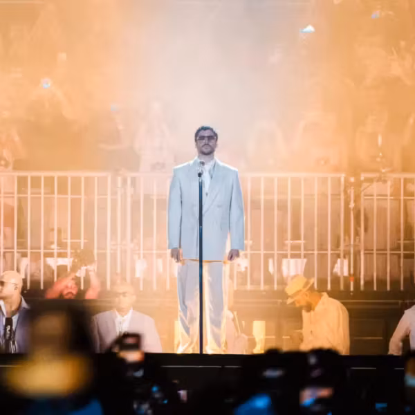 Исполнитель в белом костюме на сцене Spotify показывает топ треков