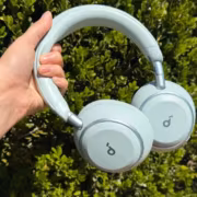 белые беспроводные наушники Soundcore Space 2 в руке