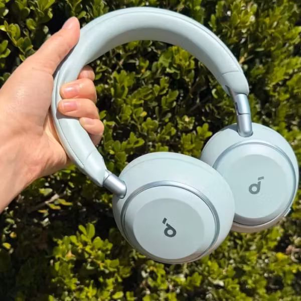 белые беспроводные наушники Soundcore Space 2 в руке