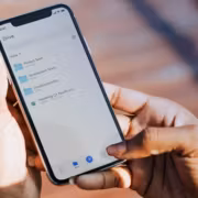 Человек держит iPhone с открытым облачным хранилищем Internxt