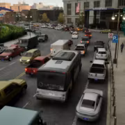 Городской трафик у здания Novastate Bus Bound Saber