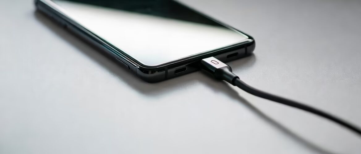 Мобильный телефон подключён к Ugreen Nexode 45 Вт зарядке на буферном фоне