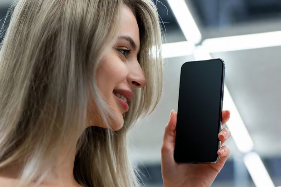 Расслабленная женщина держит смартфон в руке