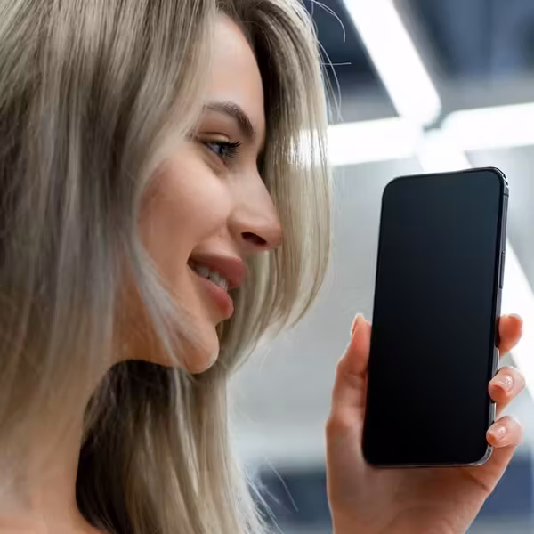 Расслабленная женщина держит смартфон в руке