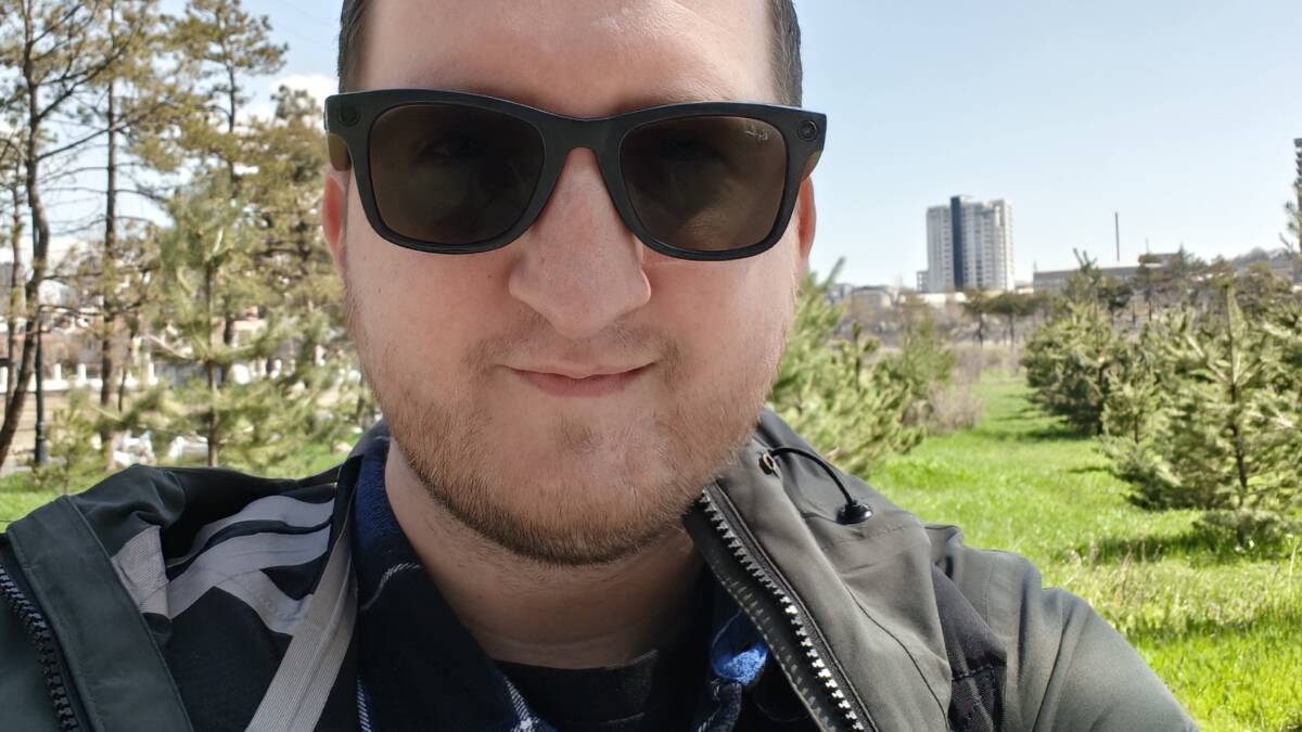 Мужчина в солнечную погоду с солнцезащитными очками на улице