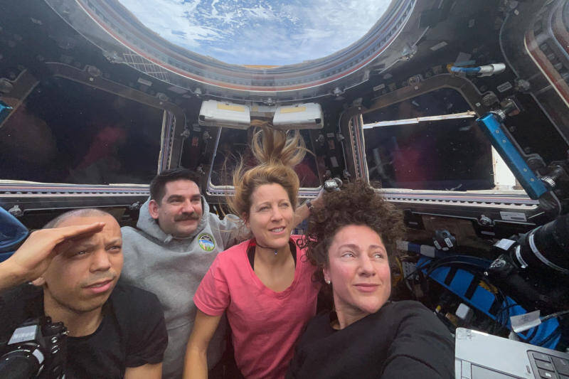 Группа астронавтов в скафандрах внутри МКС с ноутбуком HP ZBook Fury G9