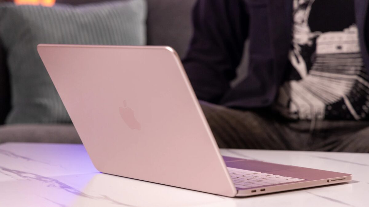 Pink MacBook и человек в черной куртке