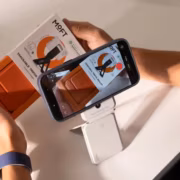 Человек с смартфоном снимает трекер и кошелёк Moft