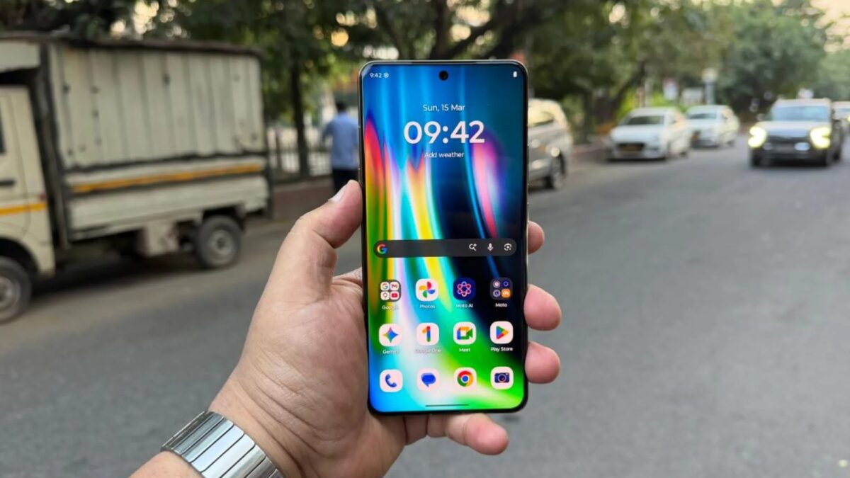 Рука держит смартфон Motorola в руке в городском окружении