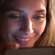 Женщина в ярком свете использует мобильный телефон клюевой мессенджер