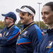 Три человека в спортивной форме на стадионе Apple TV+ Тед Лассо