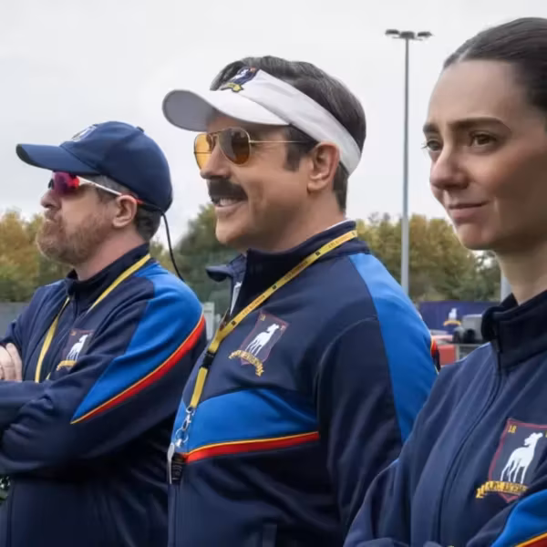 Три человека в спортивной форме на стадионе Apple TV+ Тед Лассо