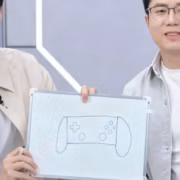 Два человека держат белую доску с рисунком консоли OnePlus