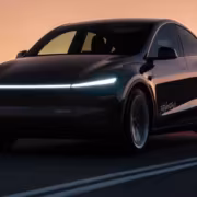 Черный электромобиль Tesla Model, едет по дороге