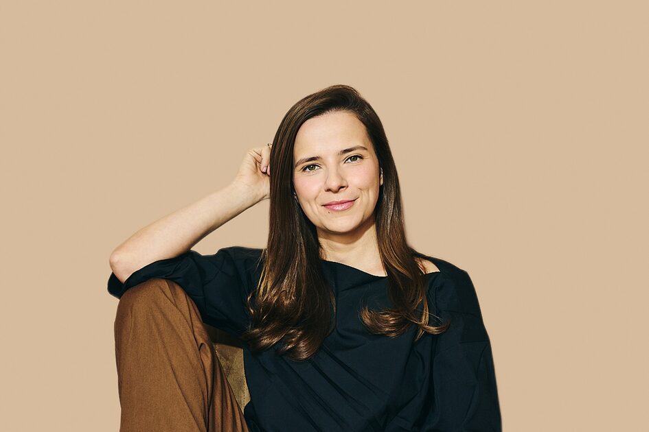 женщина сидит на полу в темной одежде улыбка