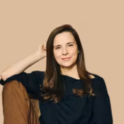 женщина сидит на полу в темной одежде улыбка