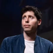 Мужчина в голубой куртке и белой футболке с короткими тёмными волосами