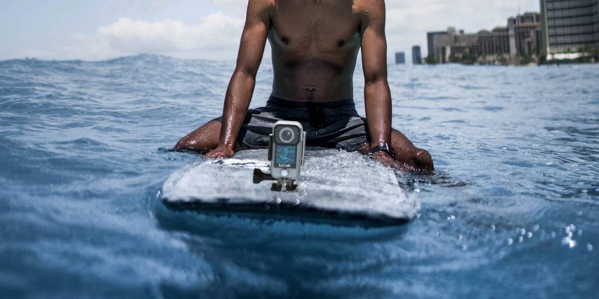 Человек на серфе с экшн-камерой SJCAM в воде