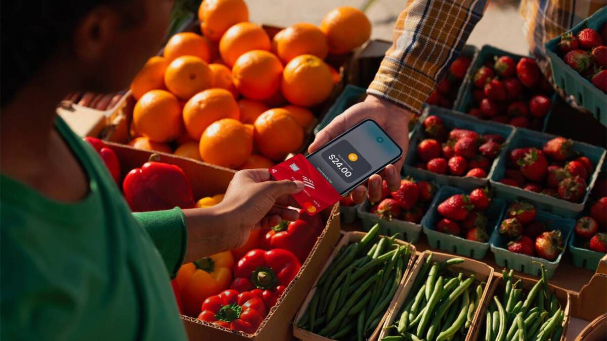 Покупатель использует iPhone с Apple Pay на рынке