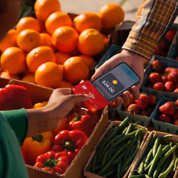 Покупатель использует iPhone с Apple Pay на рынке