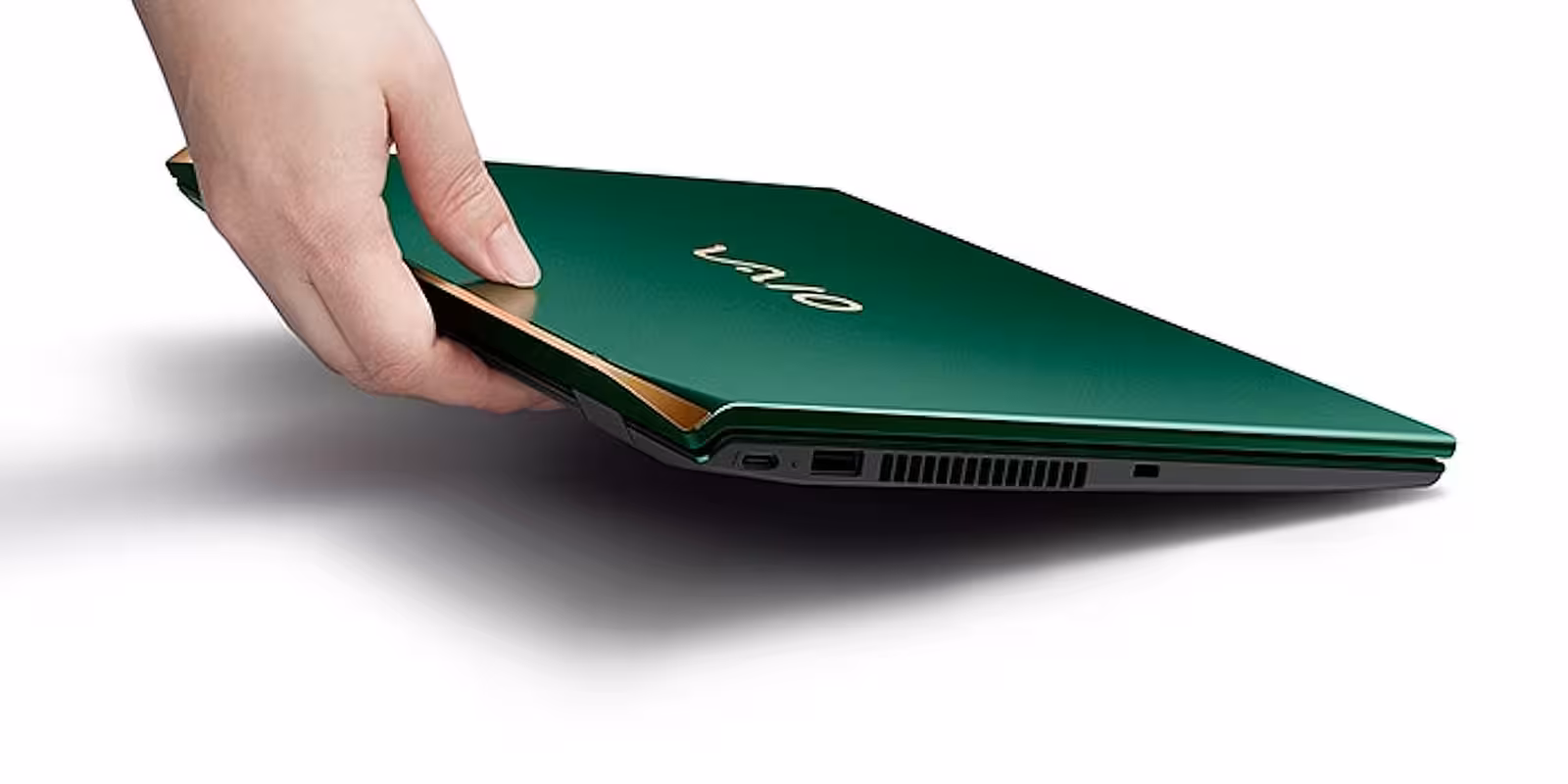 Пальцы держащее зелёный ноутбук Vaio SX14-R