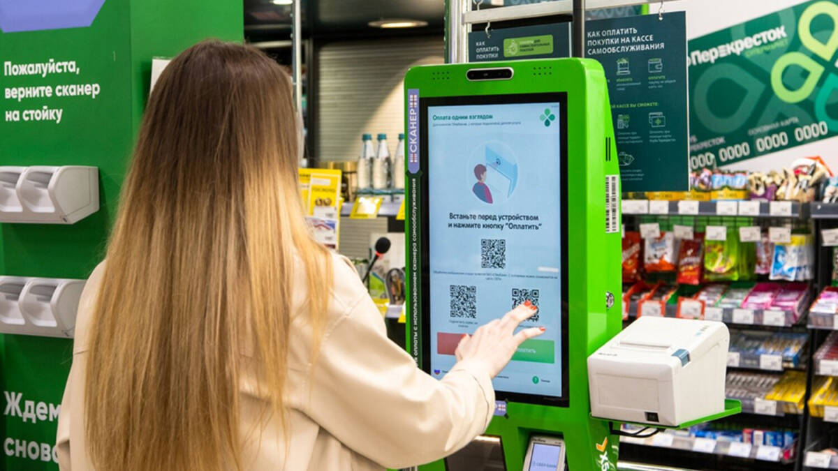 Покупатель использует биометрический терминал для оплаты Россией