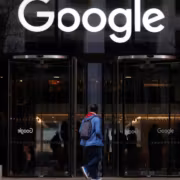 Человек у входа в офис Google с рюкзаком