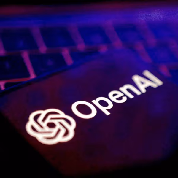 Логотип OpenAI на смартфоне на клавиатуре ноутбука