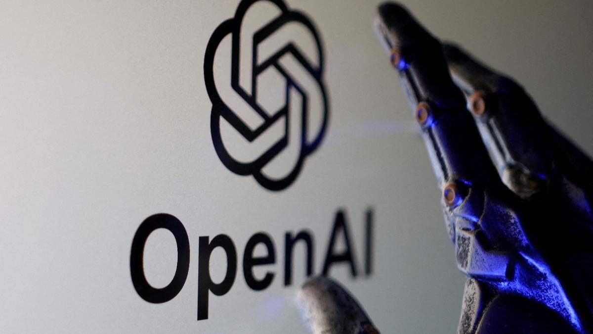 Рука в руке с роботизированными пальцами возле логотипа OpenAI