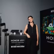 женщина в чёрном наряде возле стенда HONOR 600 и 600 Pro