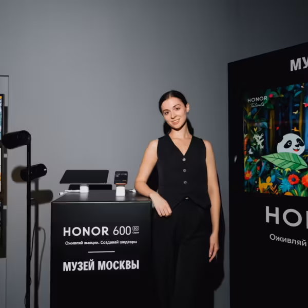 женщина в чёрном наряде возле стенда HONOR 600 и 600 Pro