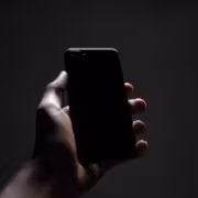 Человек держит смартфон Huawei Mate 90 в темной среде