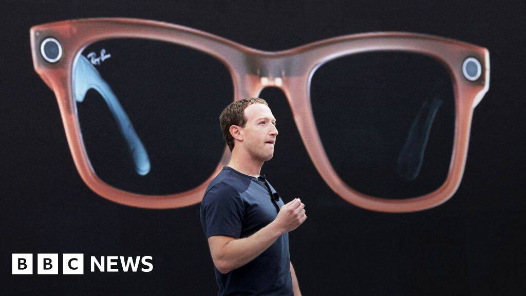 человек держит в руке очки Ray-Ban Meta крупная модель на фоне
