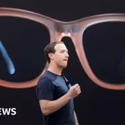 человек держит в руке очки Ray-Ban Meta крупная модель на фоне