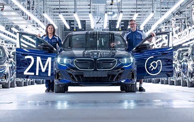 Два человека возле электромобиля BMW i4 выпущенного BMW Group перевод