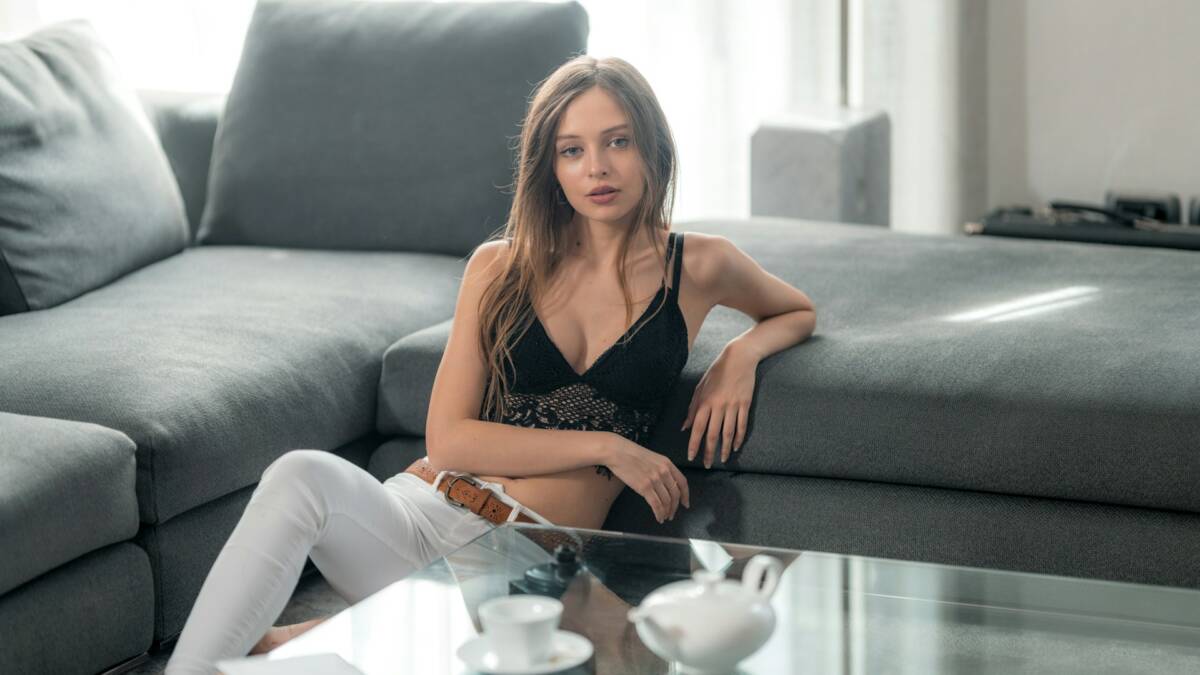 Женщина на диване в гостиной М.Видео кондиционеры