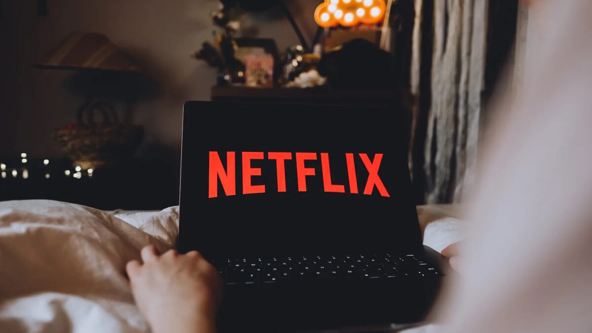 Ноутбук с логотипом Netflix на экране в темной комнате