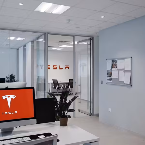 офис Tesla с логотипами и компьютером Tesla