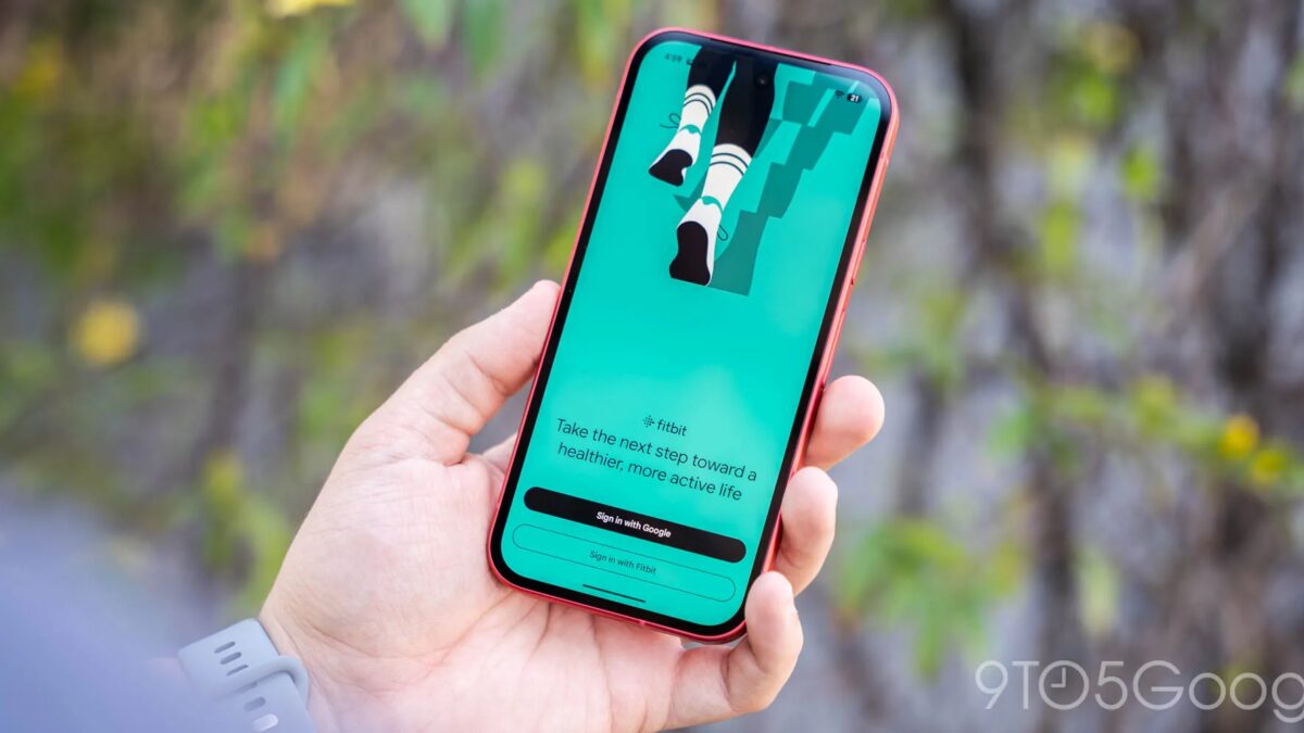 Мужчина держащий смартфон с приложением Fitbit и Google Health