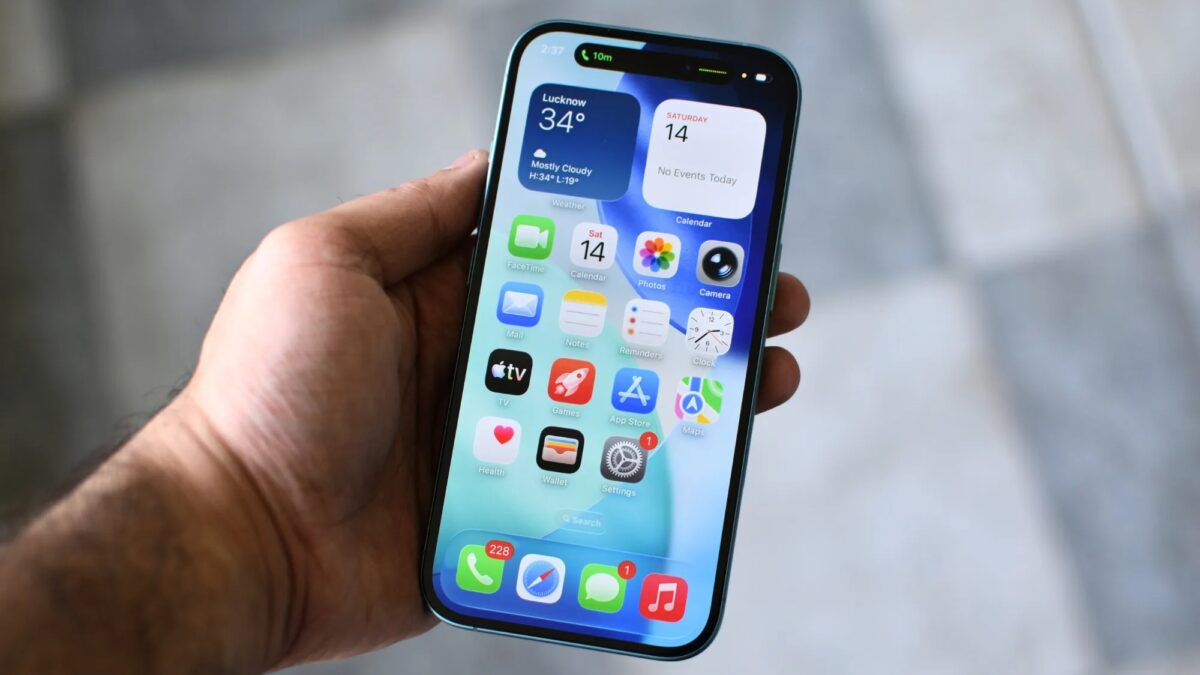 Мужчина держит iPhone с открытым экраном Safari iOS 27
