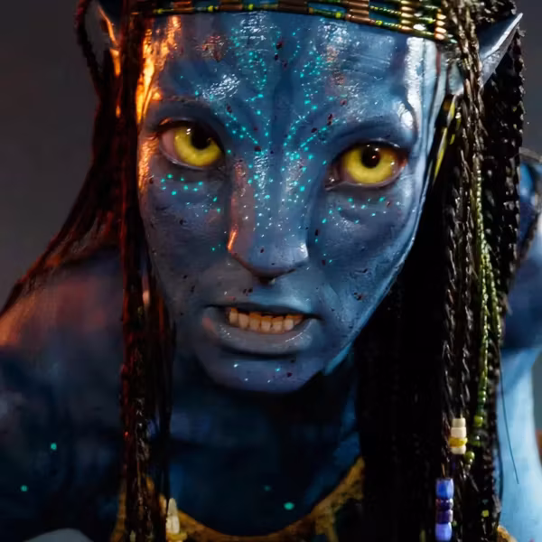 Лицо существа с яркими зелёными глазами и голубой кожей