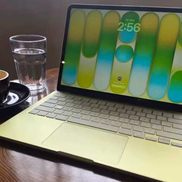 Ноутбук MacBook Neo, чашка и стекло с водой
